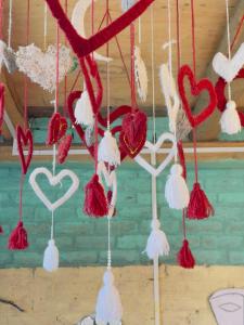 a bunch of heart ornaments hanging from a wall at Mj home in Kalgha