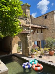 a swimming pool with two inflatables in a yard at Les 3 contes in Vallabrix