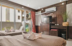 a hotel room with two beds and a flat screen tv at EBS Hostel Phuket, Kata Beach in Karon Beach +40 photos