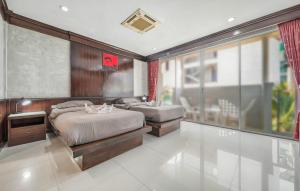 a bedroom with two beds and a large window at EBS Hostel Phuket, Kata Beach in Karon Beach