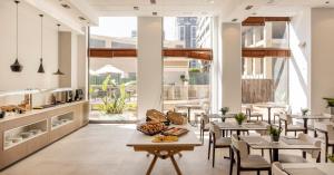 a restaurant with tables and chairs and large windows at Ilunion Valencia 3 in Valencia