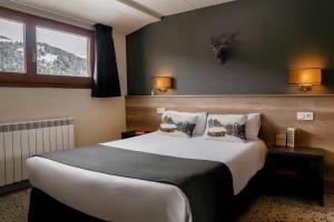 a hotel room with a large bed and a window at Hotel Austria by Pierre & Vacances in Soldeu