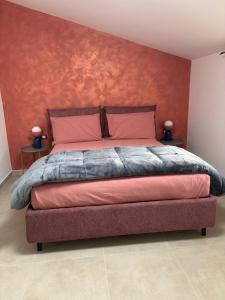 a bedroom with a large bed with a red wall at Apartment Jasmina in Venzone