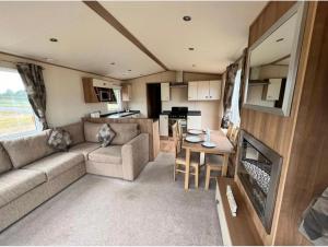 an rv living room with a couch and a table at 9 Sea View Kessingland Beach Parkdean Resorts MIN 3 NIGHT STAY in Kessingland