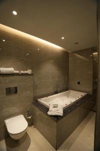 a bathroom with a bath tub and a toilet at The Murti Hotel and Banquet in Noida +41 photos