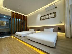 two white beds in a room with a kitchen at 枫江月 in Fenghuang County