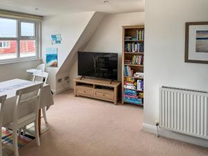 a living room with a television and a book shelf at Sandbourne in Bournemouth