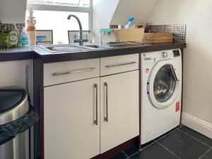 a kitchen with a sink and a washing machine at Sandbourne in Bournemouth +17 photos
