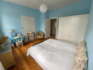 a bedroom with a white bed and a blue wall at The Old Parsonage in Søndersø