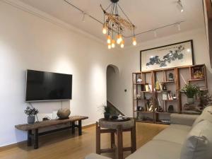 a living room with a couch and a flat screen tv at 枫江月 in Fenghuang County