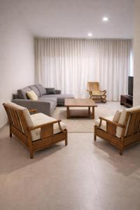 a living room with a couch and chairs and a tv at Verdant Comfort Apartment in Moka