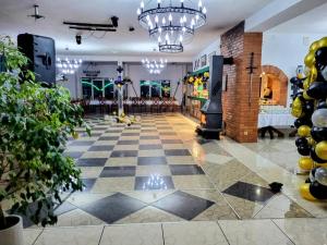 a room with a checkerboard floor and a chandelier at Gospoda Rycerska pod Grunwaldem in Grunwald