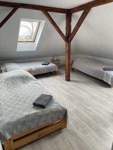 a bedroom with two beds and a window at Gospoda Rycerska pod Grunwaldem in Grunwald