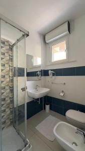 a bathroom with a sink and a glass shower at The Smerald in Alghero