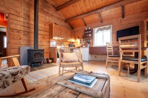 a living room with a fireplace and a table at Valen Cabins in Reine in Reine