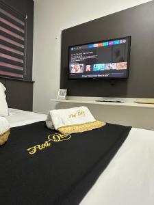 a room with a bed with a flat screen tv at Flat JK 102 in Juazeiro do Norte