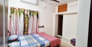 a small bedroom with a bed and a window at Sripadakuteer in Pithāpuram