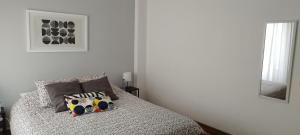 a white bedroom with a bed with two pillows at Vieira's House Suíte in Barreiro