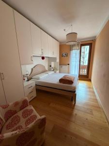 a bedroom with a bed and a chair in it at Appartamento bambi abetone in Abetone