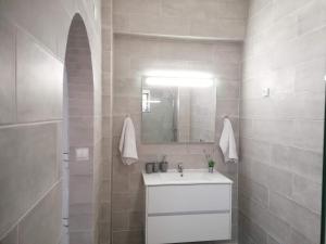 a white bathroom with a sink and a mirror at Vieira's House Suíte in Barreiro +19 photos