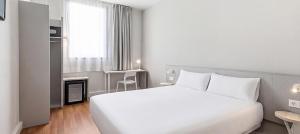 a bedroom with a large white bed and a window at B&B HOTEL Barcelona Mataro in Mataró