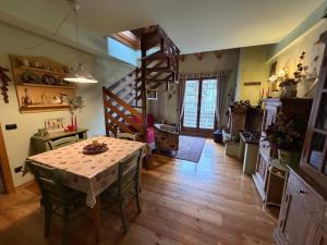 a kitchen and dining room with a table and stairs at Appartamento bambi abetone in Abetone