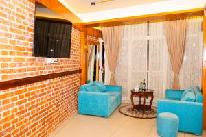 a living room with two blue chairs and a tv at Lamatar Hills Resort in Pātan