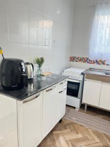 a kitchen with white cabinets and a counter top at Casa centro de Peruíbe in Peruíbe +8 photos