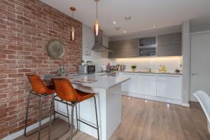 a kitchen with a white counter and a brick wall at Lancaster City Apartment in Lancaster
