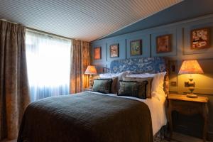 a bedroom with a large bed and a window at The Potters Heron - A Heartwood Inn in Romsey +94 photos