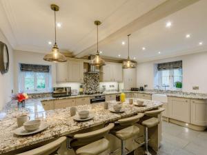 a large kitchen with a large island with bar stools at 4 Bed in Matlock oc-82198 in Cromford