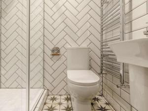 a white bathroom with a toilet and a sink at 4 Bed in Matlock oc-82198 in Cromford +15 photos