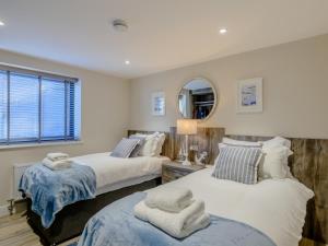 a bedroom with two beds and a mirror at 3 Bed in Belford oc-78057 in Ellington