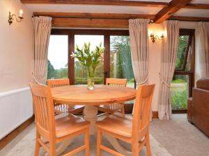 a dining room table with chairs and a vase of flowers at 2 Bed in Matlock oc-75893 in Smalley