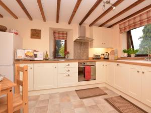 a kitchen with white cabinets and a stove top oven at 2 Bed in Matlock oc-75893 in Smalley