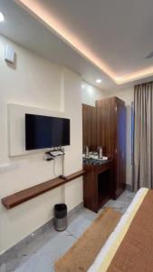 a room with a flat screen tv on a wall at Garden view by Midtown in Katra