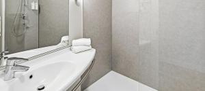 a white bathroom with a sink and a shower at B&B HOTEL Barcelona Mataro in Mataró +26 photos
