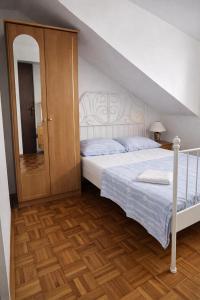 a bedroom with a white bed and a staircase at Orange city apartment's Repić in Biograd na Moru