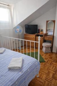 a bedroom with a bed and a tv and a desk at Orange city apartment's Repić in Biograd na Moru