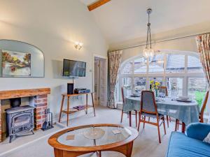 a living room with a table and a fireplace at 2 Bed in Bromyard oc-27478 in Pencombe