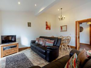 a living room with a leather couch and a tv at 3 Bed in Ellesmere oc-94419 in Dodleston