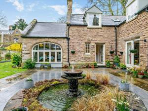 a stone house with a fountain in the yard at 2 Bed in Bromyard oc-27478 in Pencombe