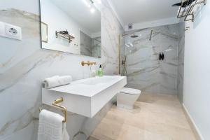 a white bathroom with a sink and a toilet at GAV Santa Pola in Ronda +77 photos
