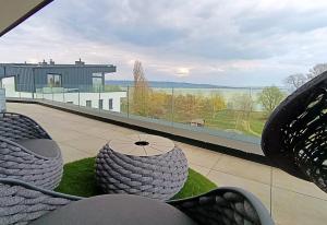 a balcony with chairs and a large window with a view at Premium Penthouse in Keszthely