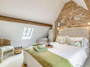 a bedroom with a large bed and a brick wall at 2 Bed in Ashbourne oc-89339 in Edwalton