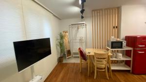a living room with a table with a television and a refrigerator at YuYu stay in Seoul