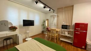 a living room with a red refrigerator and a table at YuYu stay in Seoul