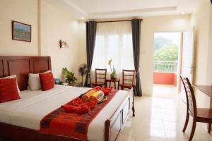 a bedroom with a large bed and a balcony at Zoé’s Paradise Waterfront Hotel in Tuktuk Siadong