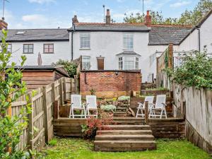 a garden with white chairs in front of a house at 2 Bed in Swindon oc-93489 in Bishopstone