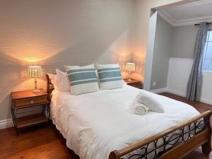 a bedroom with a large white bed with two lamps at Point Hideaway Mossel Bay in Mossel Bay